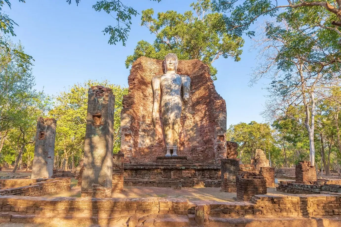 Stehende Buddha-Statue im Tempel Wat Phra Si Ariyabot im Historischen Park von Kamphaeng Phet, einer UNESCO-Welterbestätte.